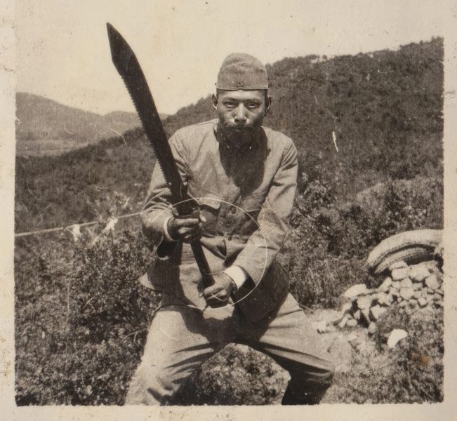 A captured Chinese dadao with unique sawback blade being held by a Japanese soldier cropped